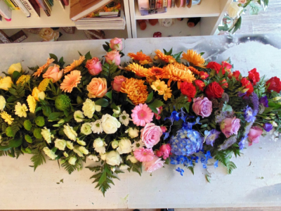 spectrum casket spray - A 6ft Casket Spray using multiple seasonal flowers in a spectrum of colours